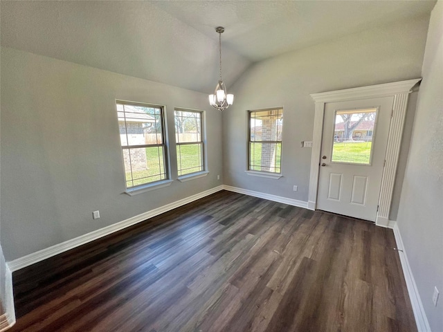 unfurnished dining area with dark wood finished floors, a notable chandelier, baseboards, and lofted ceiling