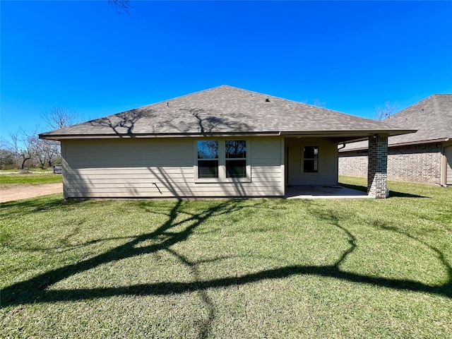 back of house featuring a patio, a shingled roof, and a yard