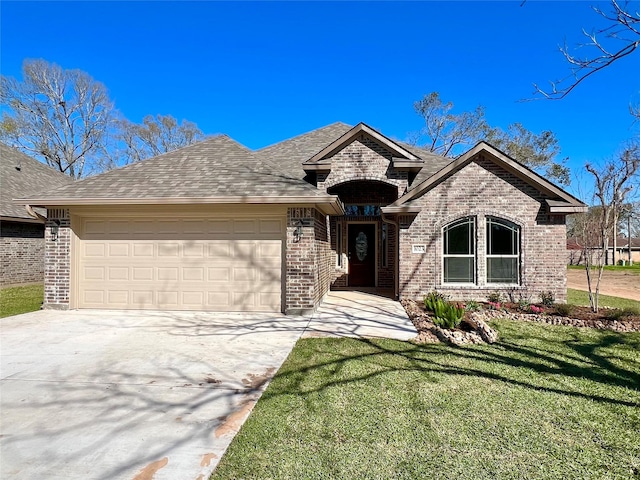 french country style house featuring brick siding, concrete driveway, a front yard, roof with shingles, and a garage