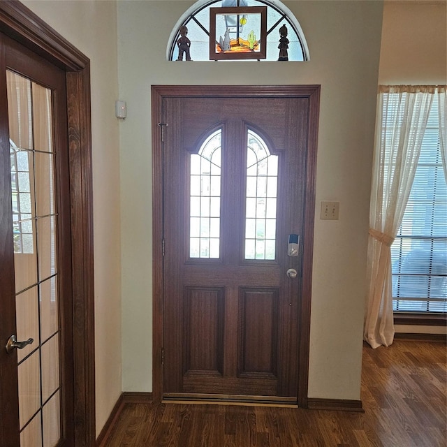 foyer entrance with dark wood-type flooring and baseboards