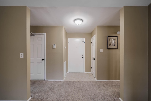 entryway with baseboards and light carpet