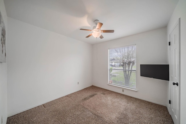 carpeted empty room with baseboards and ceiling fan