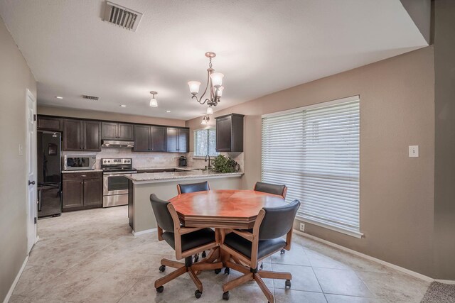 dining space with light tile patterned floors, baseboards, visible vents, and a chandelier