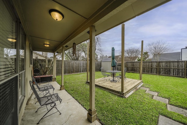 view of patio with a storage unit, an outbuilding, and a fenced backyard