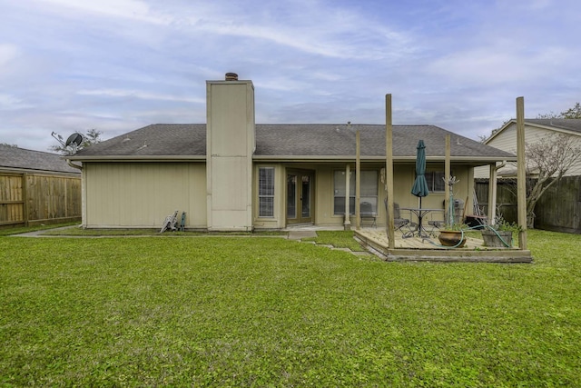 back of house featuring a patio, a yard, a fenced backyard, and a chimney