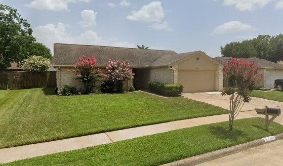 ranch-style home with a front lawn, a garage, and driveway