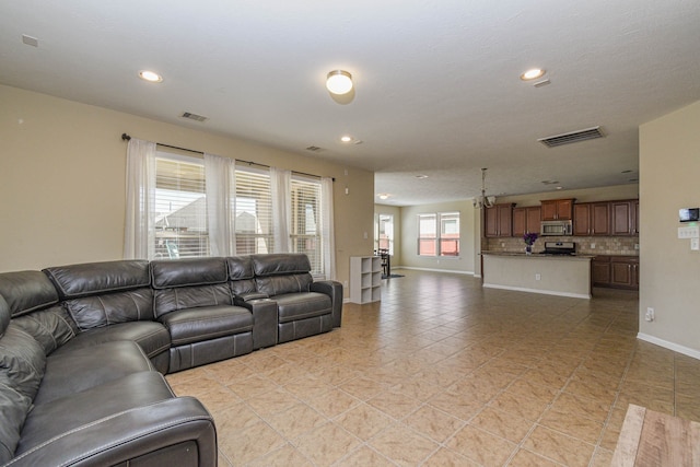 living area with recessed lighting, visible vents, and baseboards