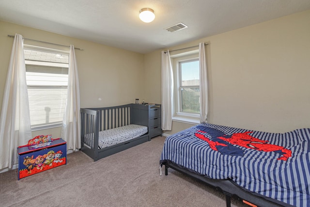 carpeted bedroom featuring visible vents