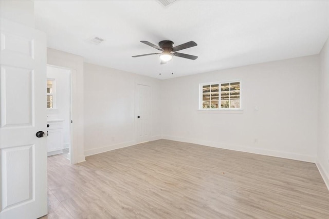 spare room featuring ceiling fan, baseboards, and light wood-style flooring