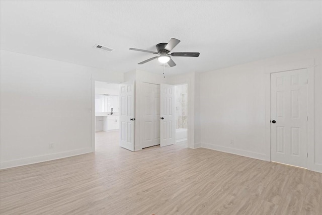 spare room featuring a ceiling fan, baseboards, visible vents, and light wood-type flooring