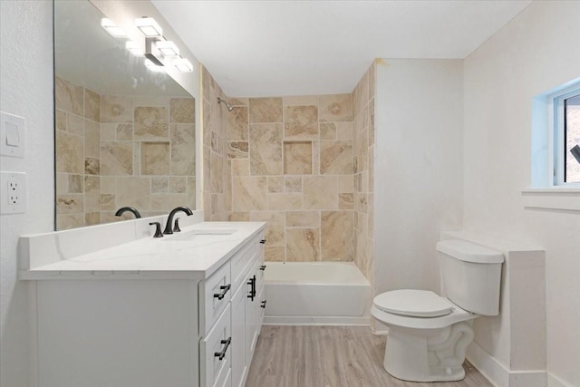 full bathroom with baseboards, toilet, shower / bathtub combination, wood finished floors, and vanity