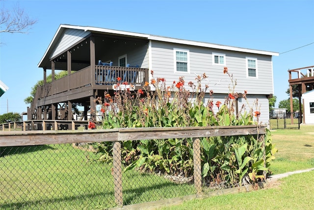 exterior space featuring a deck, a lawn, and fence