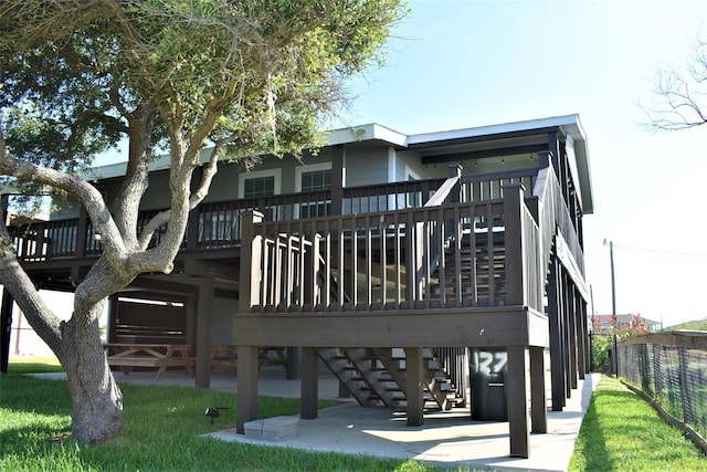 back of house with stairway, a wooden deck, a patio, and fence