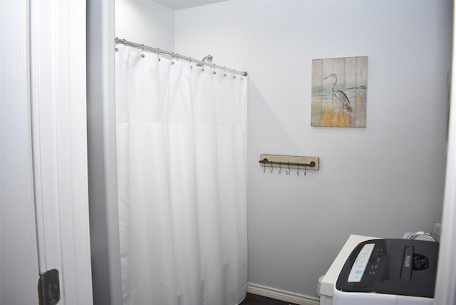 bathroom with washer / clothes dryer and a shower with curtain