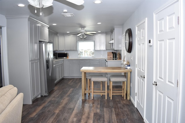 kitchen with recessed lighting, dark wood-style flooring, ceiling fan, stainless steel appliances, and under cabinet range hood