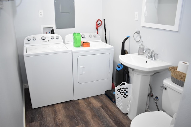 clothes washing area featuring electric panel, a sink, dark wood-style floors, separate washer and dryer, and laundry area