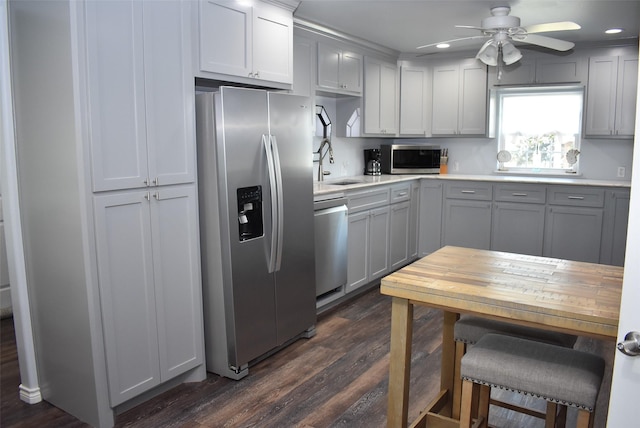 kitchen with recessed lighting, dark wood-style flooring, a sink, light countertops, and appliances with stainless steel finishes