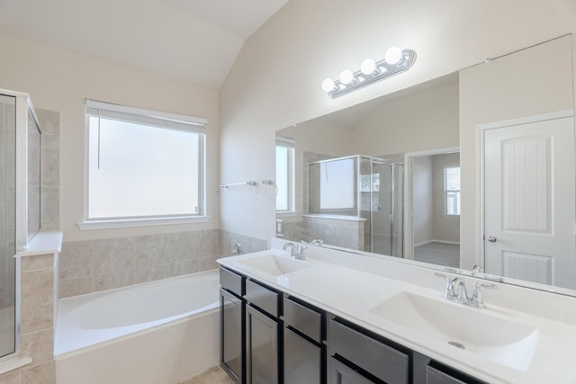 full bath with lofted ceiling, a bath, a stall shower, and a sink