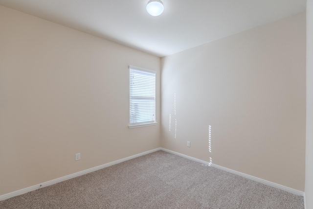 carpeted empty room with baseboards