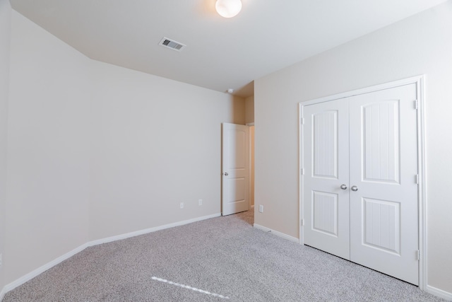 unfurnished bedroom featuring a closet, visible vents, carpet flooring, and baseboards