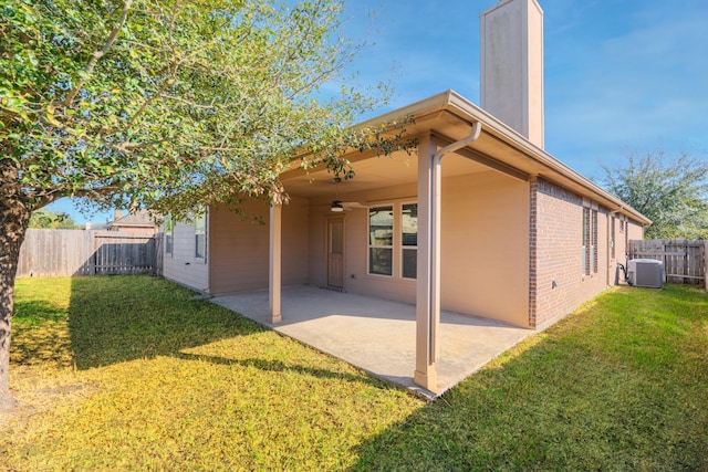 back of property featuring a patio area, cooling unit, a yard, and fence