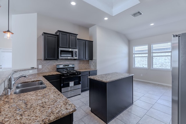 kitchen with visible vents, a sink, decorative backsplash, stainless steel appliances, and a center island