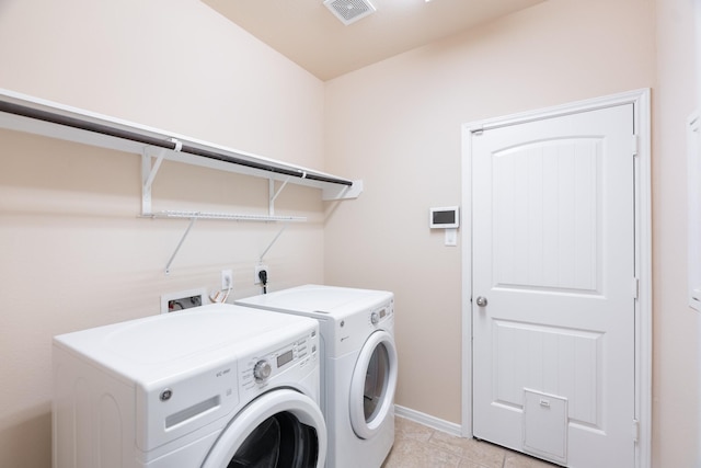 laundry area featuring visible vents, independent washer and dryer, light tile patterned flooring, baseboards, and laundry area