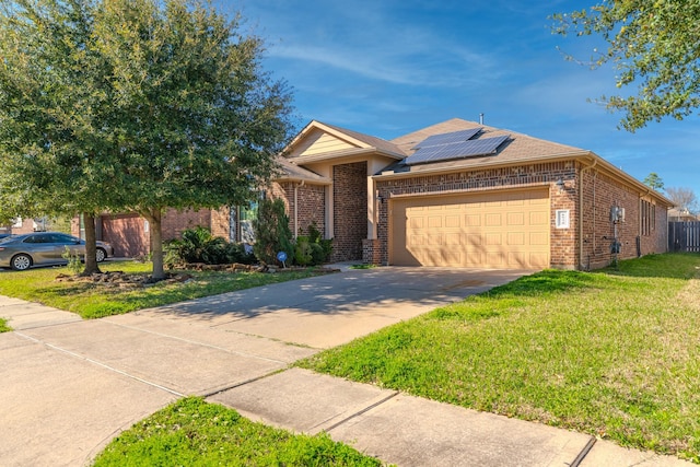 view of front of house with driveway, brick siding, solar panels, and a front yard