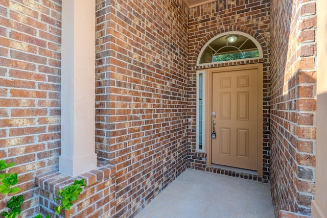 property entrance featuring brick siding