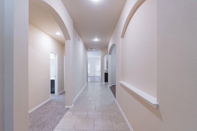 corridor featuring visible vents, recessed lighting, arched walkways, light tile patterned floors, and baseboards