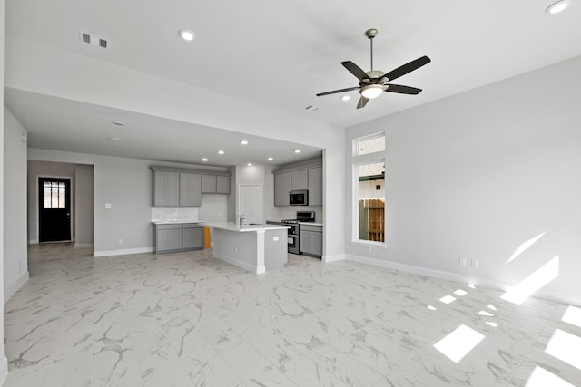 unfurnished living room featuring visible vents, recessed lighting, baseboards, and a wealth of natural light