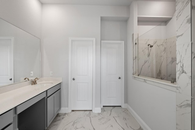 bathroom with a marble finish shower, marble finish floor, vanity, and baseboards