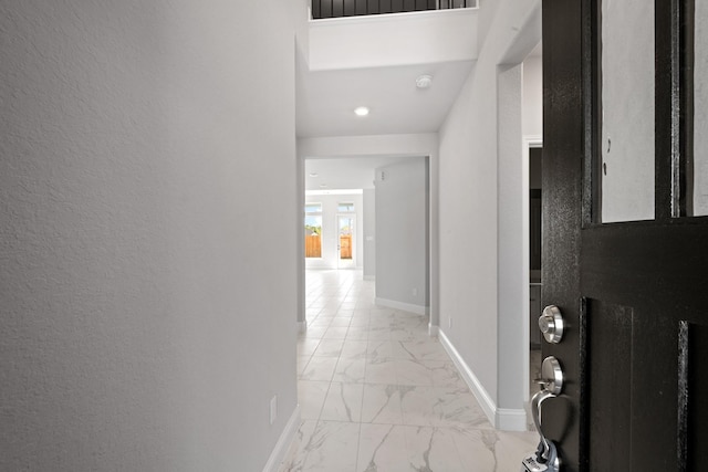 hallway featuring baseboards and marble finish floor