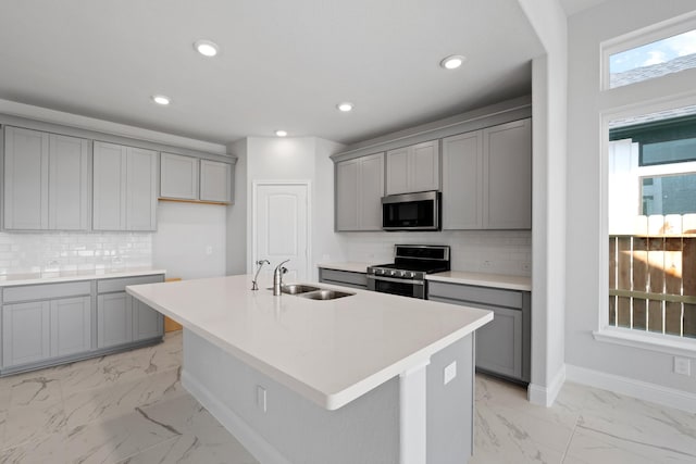 kitchen featuring recessed lighting, a sink, gray cabinetry, stainless steel appliances, and marble finish floor