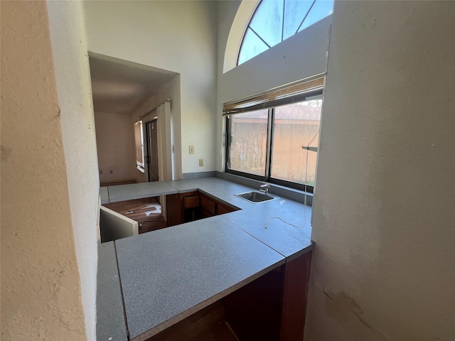 kitchen with a high ceiling, a textured wall, and a sink