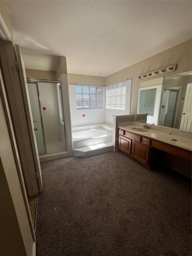 bathroom featuring a textured ceiling, carpet flooring, a shower stall, a bath, and vanity