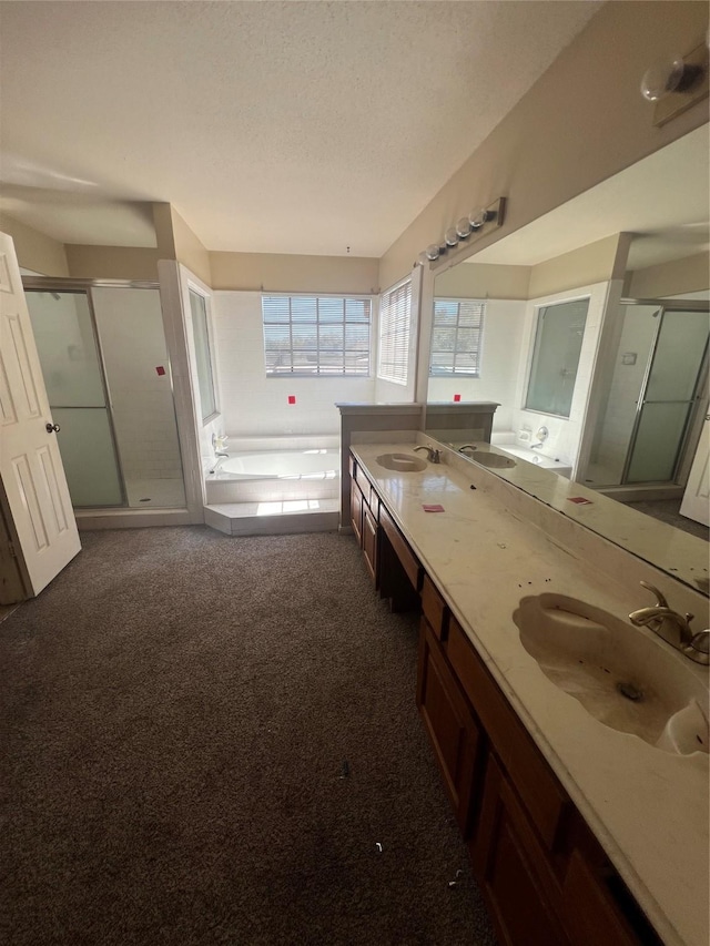 full bathroom featuring a shower stall, a bath, double vanity, and a sink