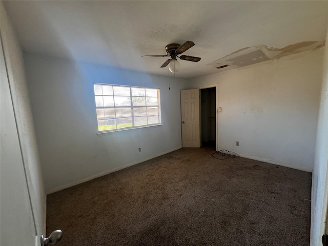 carpeted empty room with visible vents and a ceiling fan