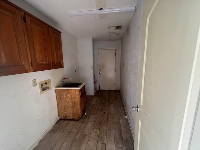 laundry room featuring wood finished floors, cabinet space, hookup for a washing machine, and a sink