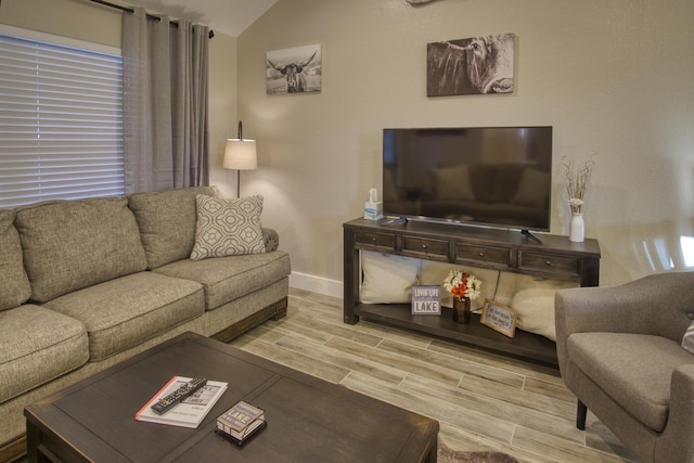 living room with baseboards, lofted ceiling, and wood finish floors