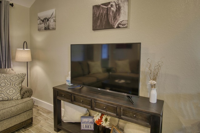 living area with baseboards and wood finished floors