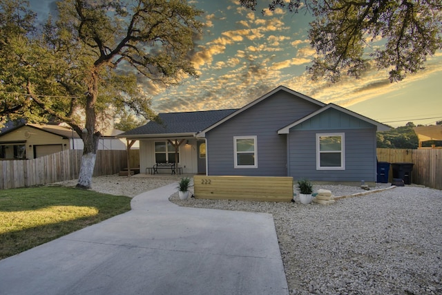 view of front of property with a front yard, a porch, fence, and board and batten siding