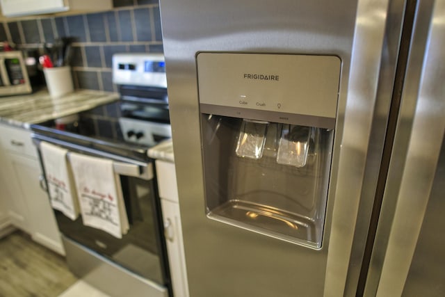 room details featuring backsplash, appliances with stainless steel finishes, and light countertops