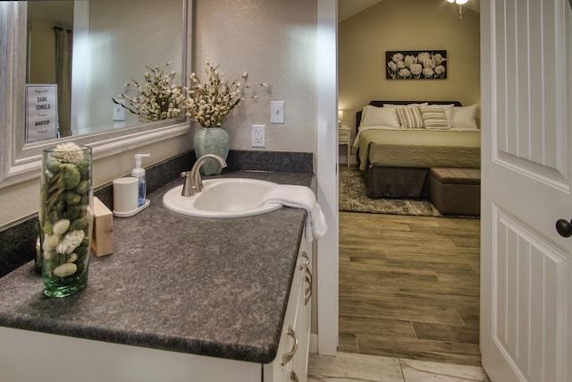 bathroom with ensuite bathroom, wood tiled floor, lofted ceiling, and vanity