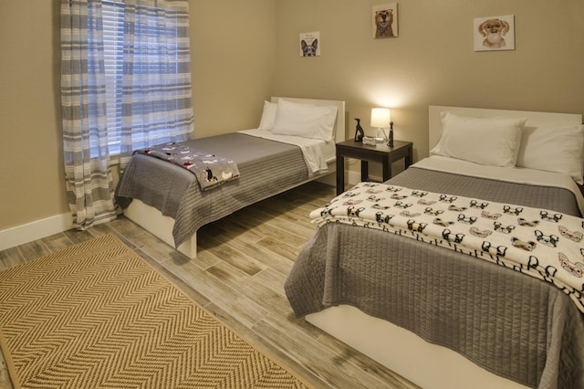 bedroom with baseboards and light wood-style flooring