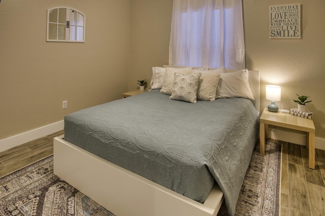 bedroom featuring baseboards and wood finished floors