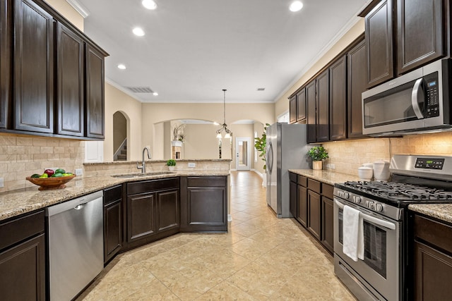 kitchen with visible vents, arched walkways, ornamental molding, a sink, and appliances with stainless steel finishes