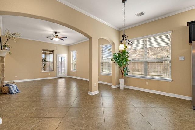 tiled empty room with a ceiling fan, visible vents, baseboards, arched walkways, and crown molding