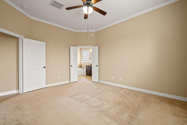 unfurnished bedroom with visible vents, crown molding, baseboards, light colored carpet, and ensuite bathroom