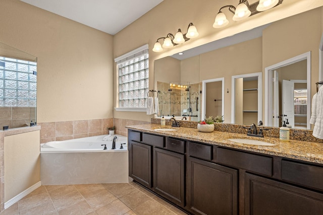 bathroom with a sink, a garden tub, double vanity, and a shower stall